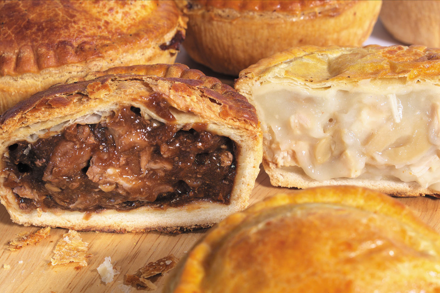 Cross-section of beef pie and chicken-and-mushroom pies showing the hand-crimped pastry and gravy filling